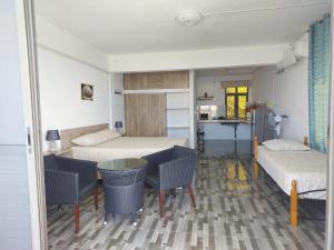 a room with two beds and a table and chairs at Sea View Rodrigues - Mourouk in Rodrigues Island