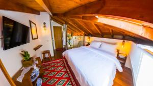 a bedroom with a large bed and a tv at Sokak Boutique Hotel in Berat