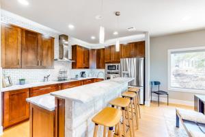 a kitchen with wooden cabinets and a bar with stools at Bright & Spacious Family Home with Firepit, Lake Views, Furnished Deck, Free WiFi in Lago Vista