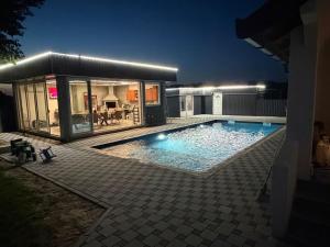 a swimming pool in front of a house at night at Vikend Kuca Okanovic in Gradačac