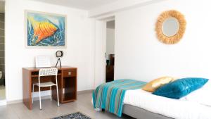 a bedroom with a bed and a desk with a mirror at Casinha Alice in Nazaré