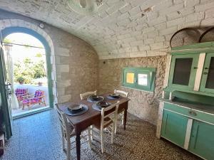 a kitchen with a wooden table and chairs in a room at Pedra e Lozzu in Sedini