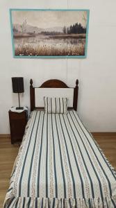 a bed in a bedroom with a painting on the wall at Casa Galache in Vila Franca de Xira