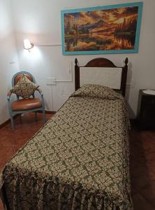 a bedroom with a bed and a painting on the wall at Casa Galache in Vila Franca de Xira