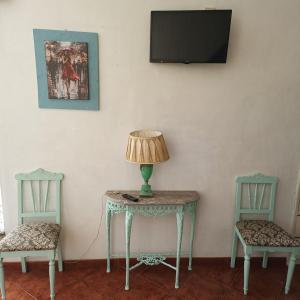 a table with a lamp on it with two chairs at Casa Galache in Vila Franca de Xira
