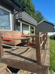 a wooden deck with a hammock and a table at Leilighet i hus in Sarpsborg