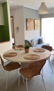 a dining room table with chairs and a table with plates at Apartamentos en playa Canido in Malpica