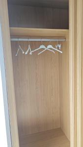 a closet with three hangers of white clothes at Apartamentos en playa Canido in Malpica +71 photos