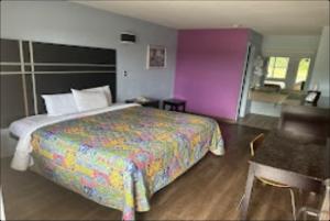 a bedroom with a large bed with a colorful bedspread at Relax Inn Hotel in Birmingham