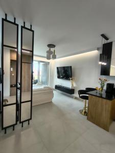 a large living room with a table and a tv at Mazury Glam Studio in Giżycko