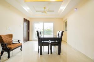 a dining room with a table and chairs and a window at Capital O RR Towers by CJ in Vijayawāda +50 photos