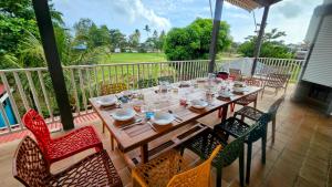 a wooden table and chairs on a patio at Les 2 Cocotiers - Maison d'hôtes d'Eugénie in Sainte-Luce