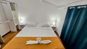 a bedroom with a bed with two towels on the floor at Les 2 Cocotiers - Maison d'hôtes d'Eugénie in Sainte-Luce