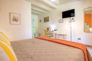 a bedroom with a bed with an orange blanket on it at Tra Cielo e Mare Rooms Rio Marina in Rio nellʼElba