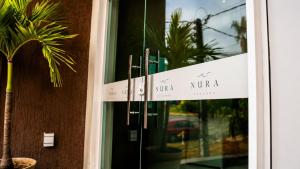 a door to a hotel with a palm tree outside at Nura Pousada in Maragogi +28 photos