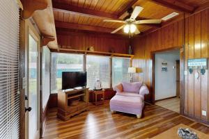 a living room with a ceiling fan and a chair at Classic Lakefront Cottage with Private Dock, Lovely Lake View, Backyard & WiFi in Kingsland