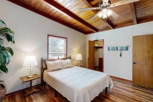 a bedroom with a bed and a ceiling fan at Classic Lakefront Cottage with Private Dock, Lovely Lake View, Backyard & WiFi in Kingsland