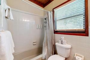 a white bathroom with a toilet and a shower at Classic Lakefront Cottage with Private Dock, Lovely Lake View, Backyard & WiFi in Kingsland +14 photos