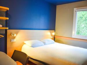 a bedroom with a white bed and a window at ibis budget Rodez in Rodez +62 photos