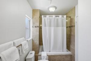 a bathroom with a shower curtain and a toilet at Sunset Motel in Santa Barbara +51 photos