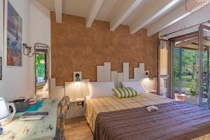 a bedroom with a large bed and a desk at Tra Cielo e Mare Rooms Rio Marina in Rio nellʼElba