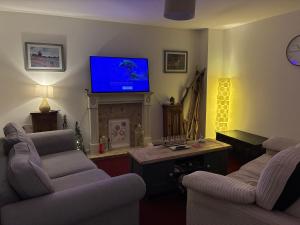 a living room with two couches and a tv at StaywithusHighbridge in Highbridge
