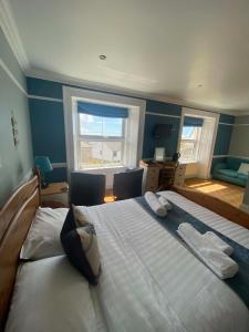 a bedroom with two large beds and a window at The Top House Inn in Lizard