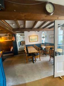 a dining room with tables and chairs and a clock at The Top House Inn in Lizard
