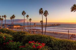 a view of a beach with palm trees and a pier at San Clemente Surf Inn in San Clemente