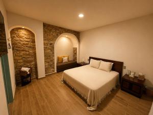 a bedroom with a bed in a room with a stone wall at Hotel Bugambilia in Zimapán +37 photos