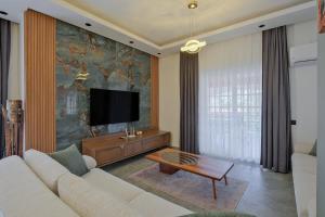 a living room with a couch and a flat screen tv at Villa Ahad in Fethiye