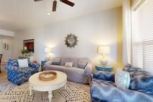 a living room with blue couches and a table at Hill Country Corner Condo at The Waters - Central AC, Lake Views & Pool in Horseshoe Bay