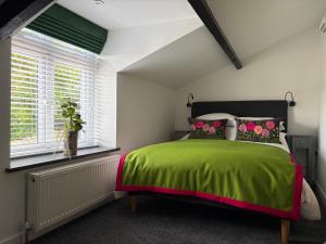a bedroom with a green bed and a window at 10 Crickhowell Cottages, Standard Street, Central Crickhowell in Crickhowell
