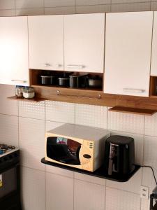 a microwave on a shelf in a kitchen at Casas Bela da Chapada in Lençóis