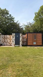 a modern house with a stone wall and a garage at Star Gazing Dome 1 with cozy log burner in Horspath