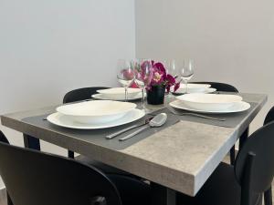 a table with plates and wine glasses on it at Makala Accommodation in Split