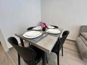 a dining room table with chairs and plates and wine glasses at Makala Accommodation in Split