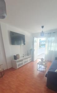 a living room with a couch and a tv at Volcán de la Corona House in Punta Mujeres