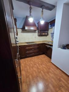 a kitchen with wooden cabinets and a wooden floor at Volcán de la Corona House in Punta Mujeres