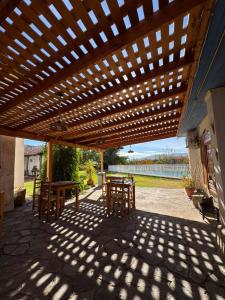 a wooden pergola with tables and chairs on a patio at Hostal Almendral in San Felipe