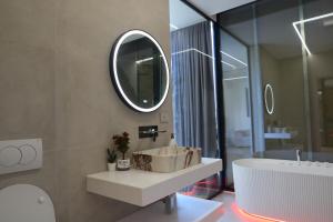 a bathroom with a sink and a mirror and a tub at Panorama Hill Villa Tirana - Private Pool & Views in Tirana +16 photos