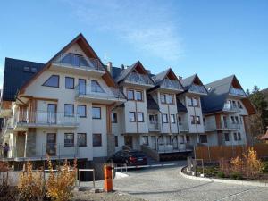 un grande edificio con un'auto parcheggiata di fronte di Bystra Woda Studio Zakopane a Zakopane
