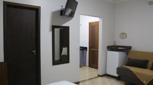 a living room with a mirror and a couch at Hospedagem Na Rota do Enxaimel - Andar Térreo ou Superior - Alles Acer in Pomerode