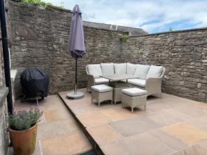 a patio with a table and chairs and an umbrella at 10 Crickhowell Cottages, Standard Street, Central Crickhowell in Crickhowell
