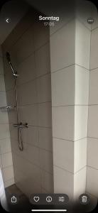 a shower stall in a bathroom with white tiles at 208 Apartment Ania in Koszalin +9 photos