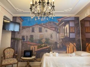 a room with a painting on the wall with two beds at Hostal Boutique Puerta del Sol in Torrelavega