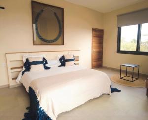 a bedroom with a large white bed and a mirror at Villa Tarrafal in Somone