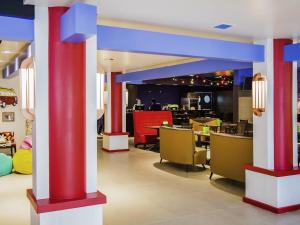 a restaurant with red and blue columns and chairs at Ibis Styles Porto Alegre Centro - proximo rodoviaria, Araujo Vianna e hospitais in Porto Alegre