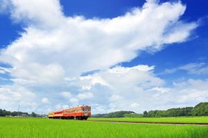 a red train traveling through a green field at KANEAGE BASE 14名までokの大型一棟貸し 家族旅行 合宿遠征 長期滞在に 海浜公園大洗20分 in Hitachinaka +52 photos