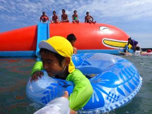 a young boy in the water with an inflatable at KANEAGE BASE 14名までokの大型一棟貸し 家族旅行 合宿遠征 長期滞在に 海浜公園大洗20分 in Hitachinaka